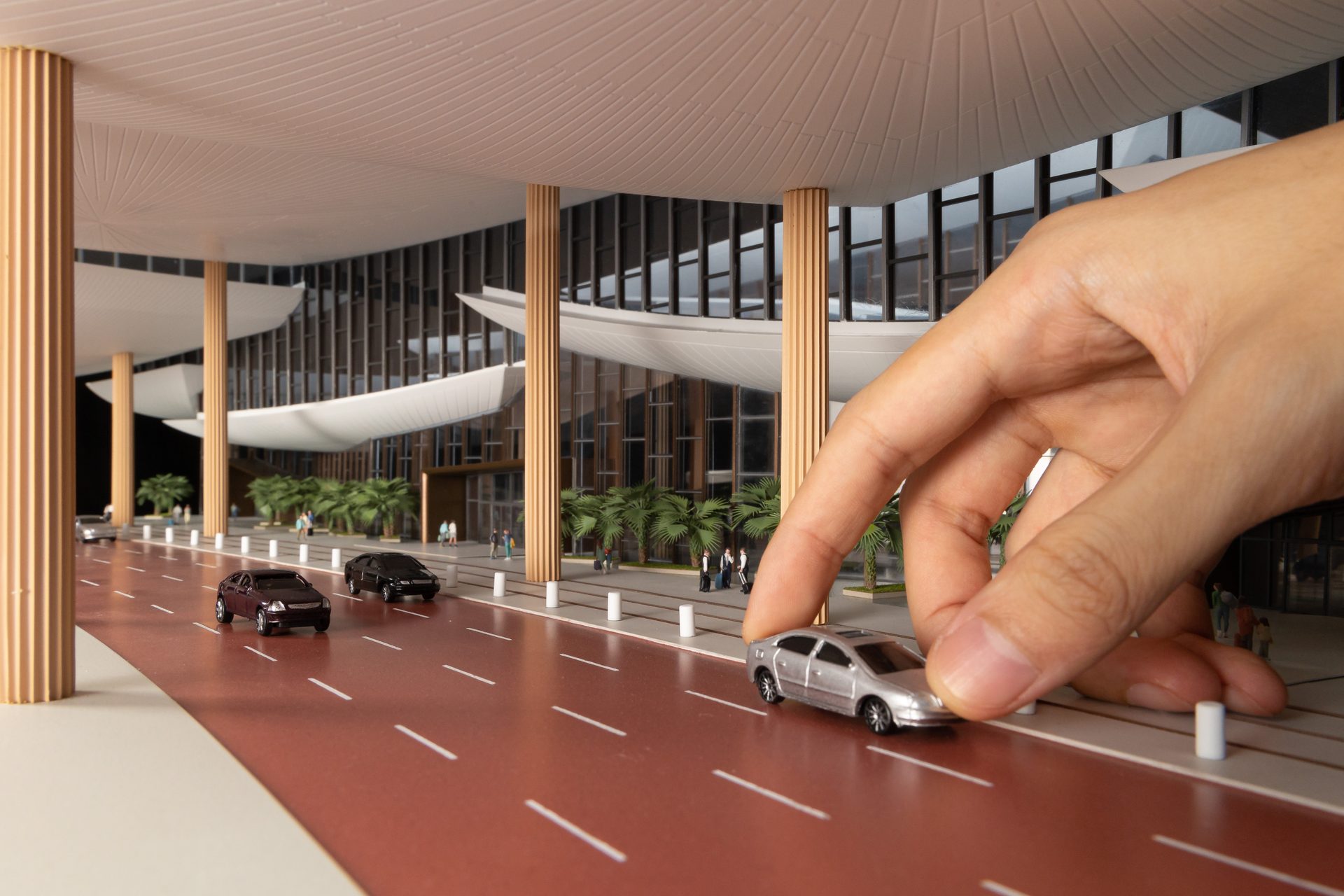 Craftsman placing miniature car on airport model